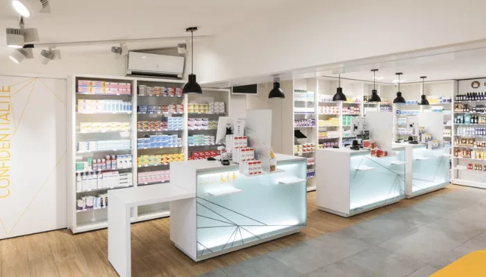 Intérieur d'une pharmacie moderne avec des étagères remplies de médicaments et de produits de santé.